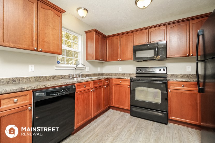 a kitchen with wooden cabinets and black appliances