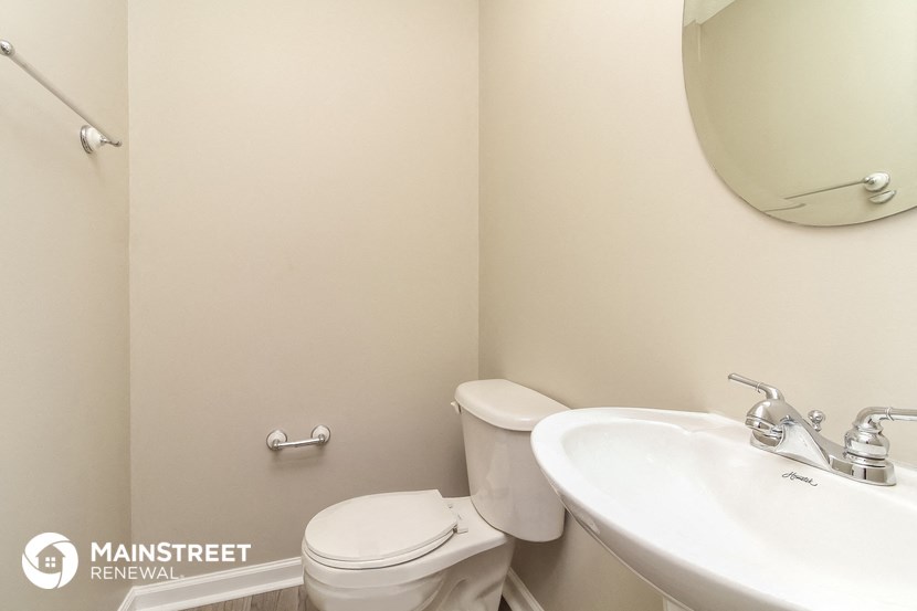 a bathroom with a sink toilet and a mirror