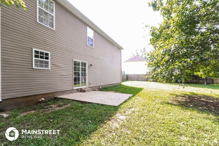 the backyard of a house with a patio and a yard