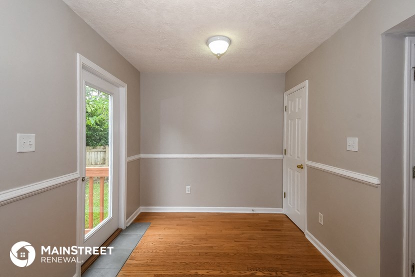 the interior of an empty room with wooden floors and grey walls