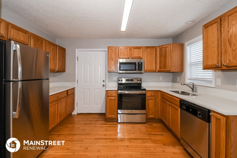 a kitchen with wooden cabinets and stainless steel appliances