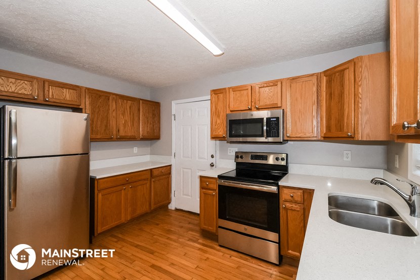 a kitchen with wooden cabinets and stainless steel appliances