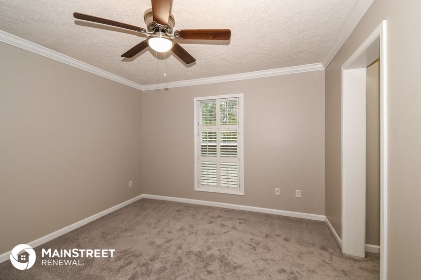 a empty room with a ceiling fan and a window