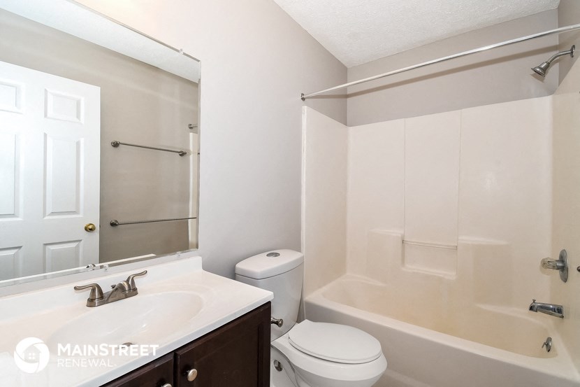 a bathroom with a shower toilet and sink and a mirror