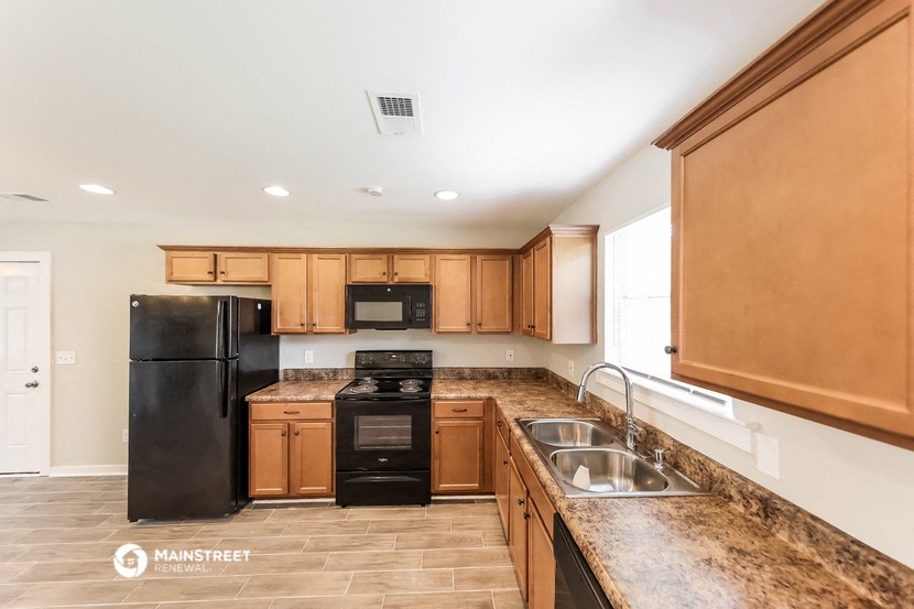 a kitchen with black appliances and wooden cabinets