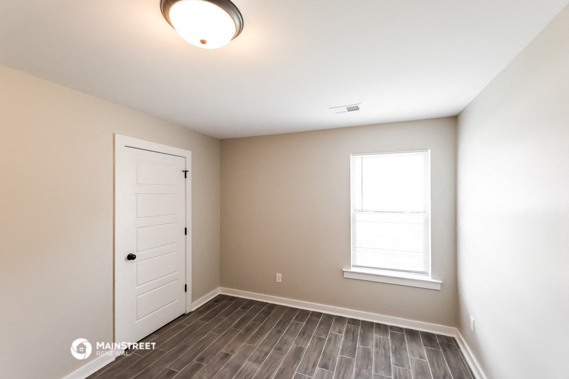 an empty room with a white door and a window
