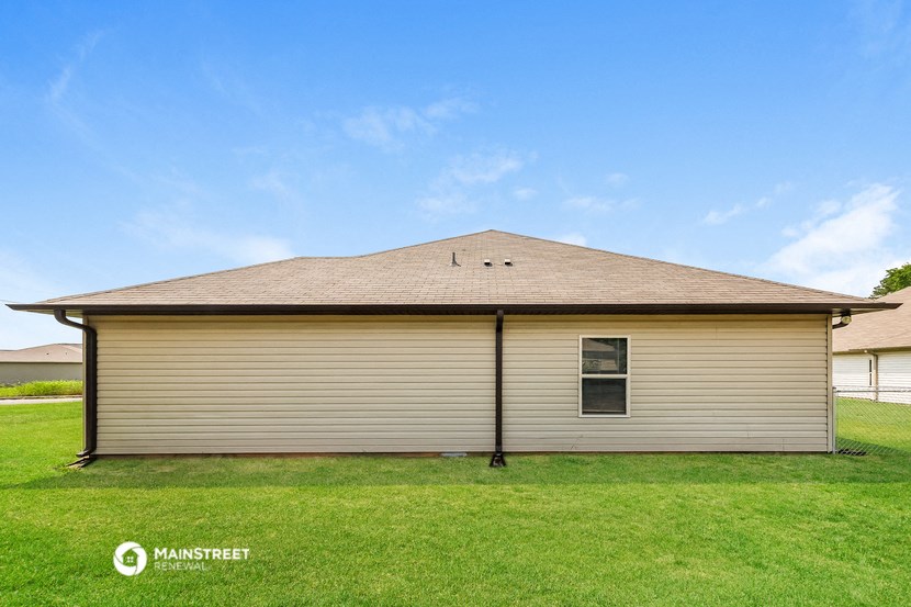 the view of a small house with a grass yard