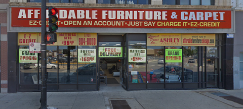 the front of a furniture and carpet store on a city street