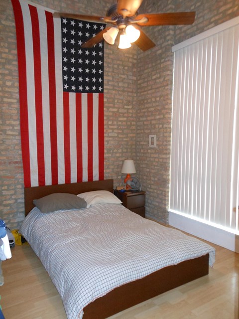 a bedroom with a bed and an flag on the wall