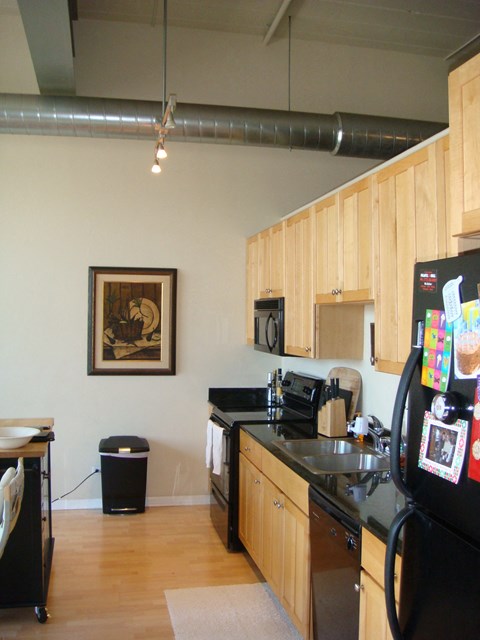 a kitchen with black appliances and wooden cabinets