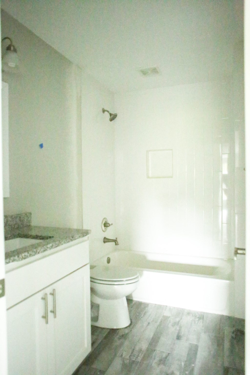 a white bathroom with a toilet and a tub and a sink