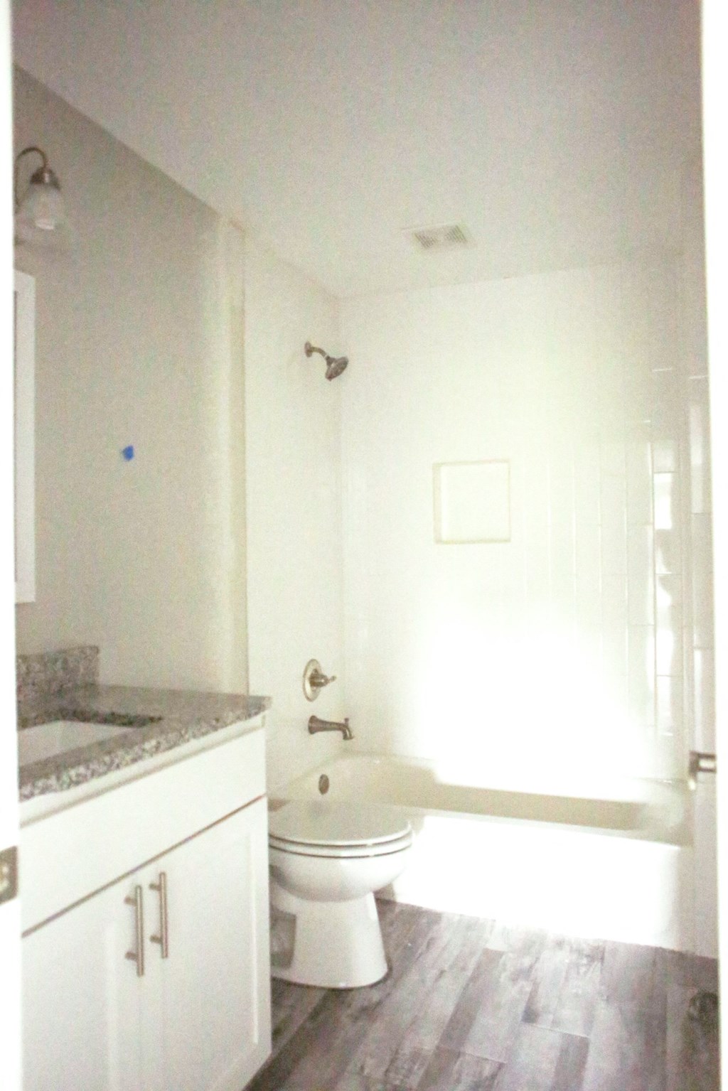 a white bathroom with a toilet and a tub and a sink