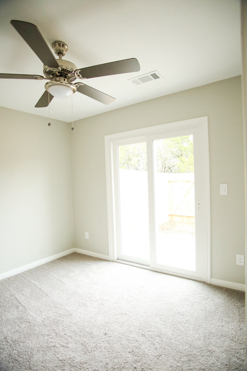 an empty living room with a ceiling fan