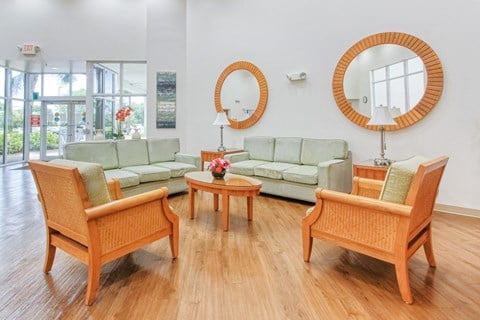 a living room with couches and chairs and a mirror