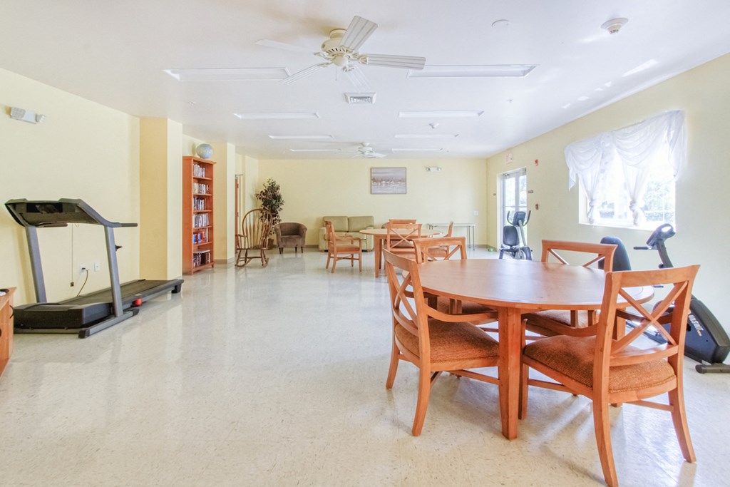 community room with tables, chairs, and exercise equipment