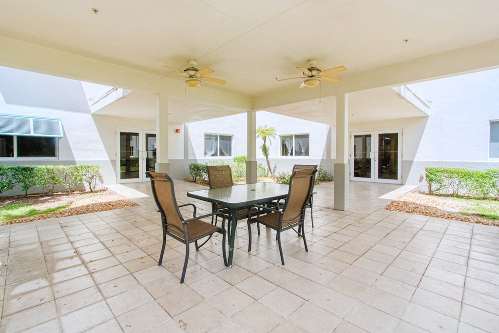 covered patio with ceiling fans and table and chairs