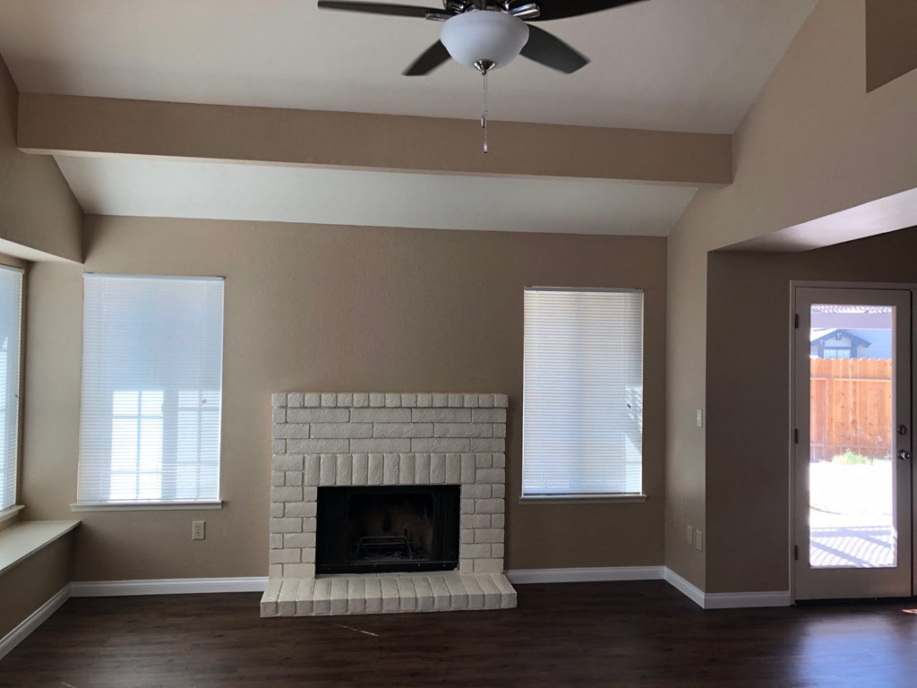 a living room with a fireplace and a ceiling fan