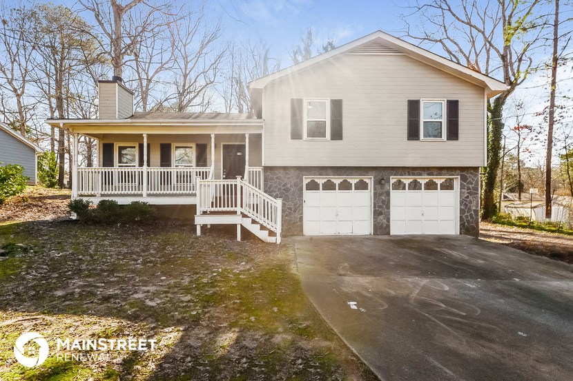 a white house with two garage doors and a driveway