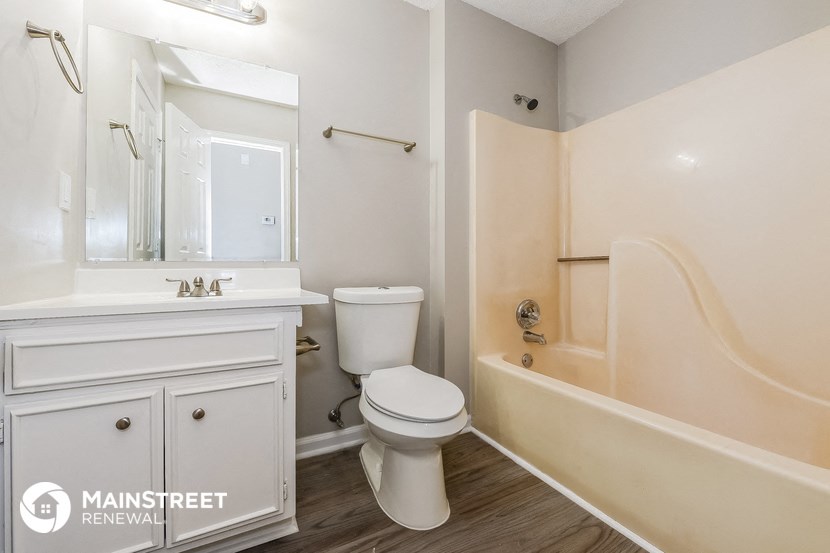 a bathroom with a toilet and a bath tub and a sink