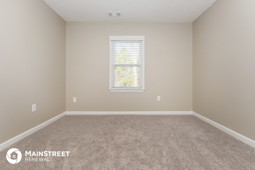 a spacious room with carpet and a window