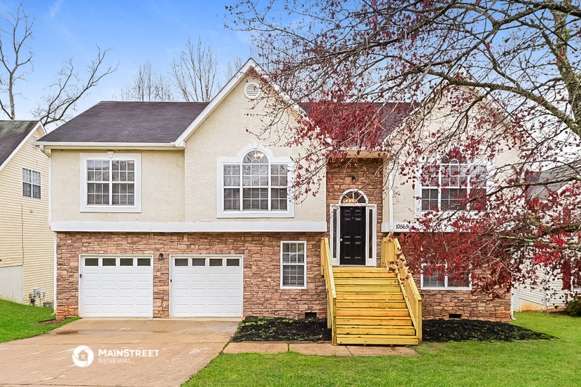 a brick house with a front yard and a tree