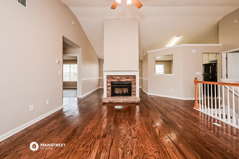 the living room of an empty house with a fireplace