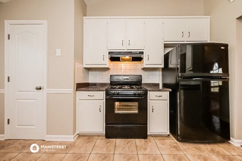 a kitchen with black appliances and white cabinets