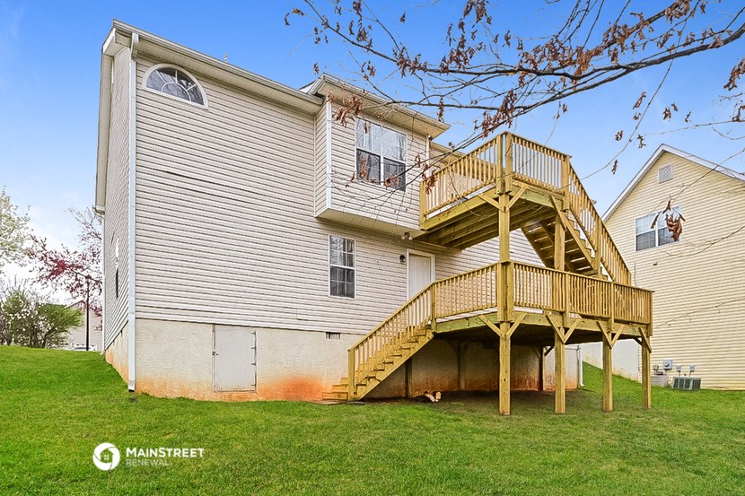 a large white house with a wooden deck on top of it