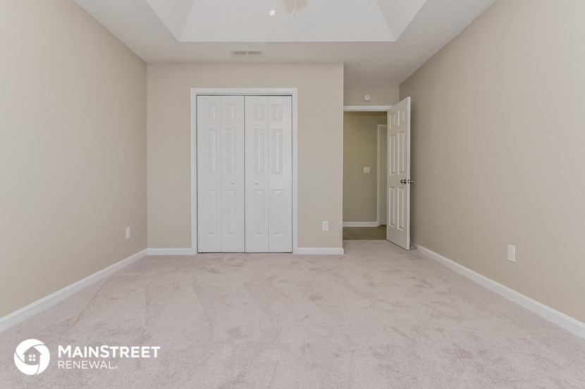 the spacious living room with white doors and beige walls