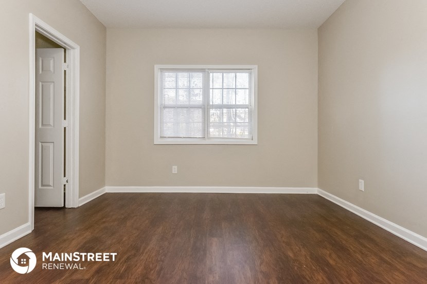 the interior of an empty room with wooden floors and a window