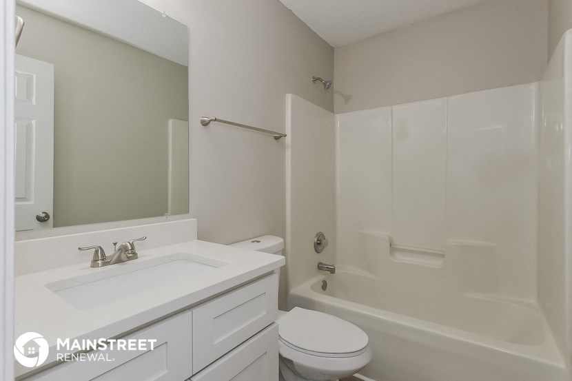 a white bathroom with a white sink and a shower and a toilet