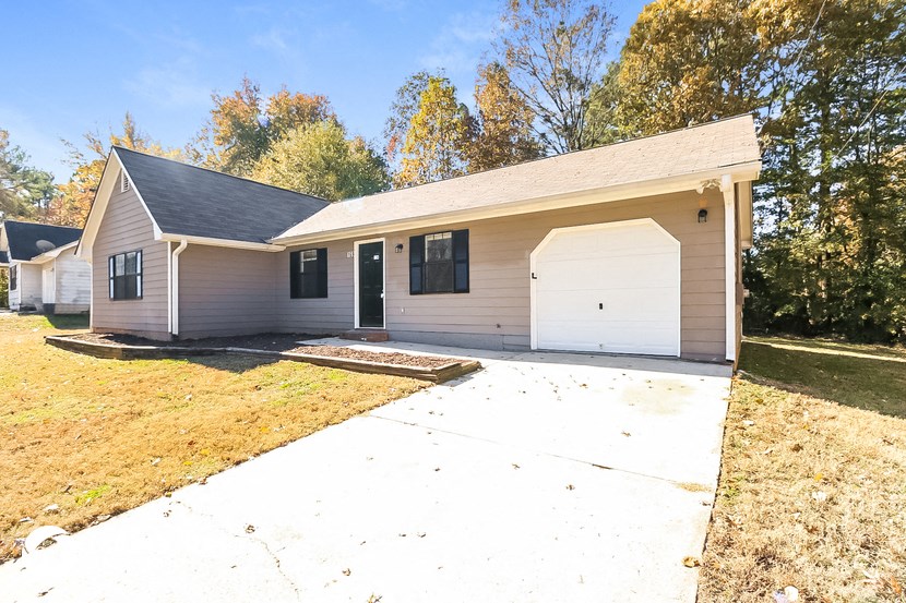 a white house with a driveway and a white garage door