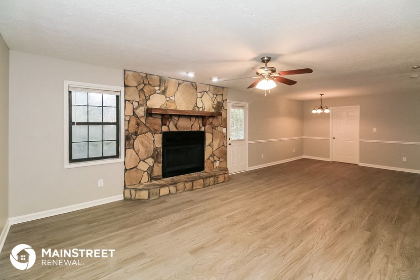 a living room with a fireplace and a ceiling fan