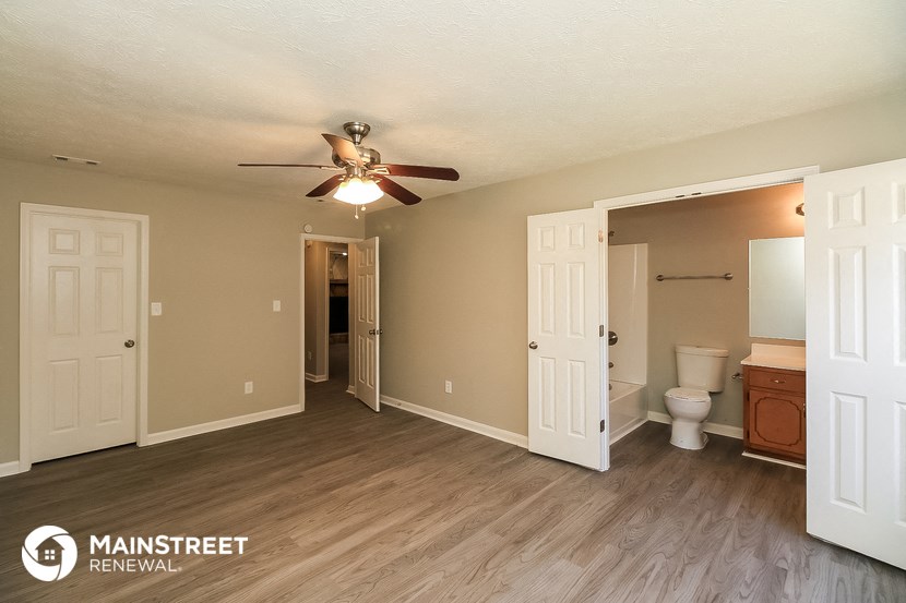 a living room with a ceiling fan and a bathroom