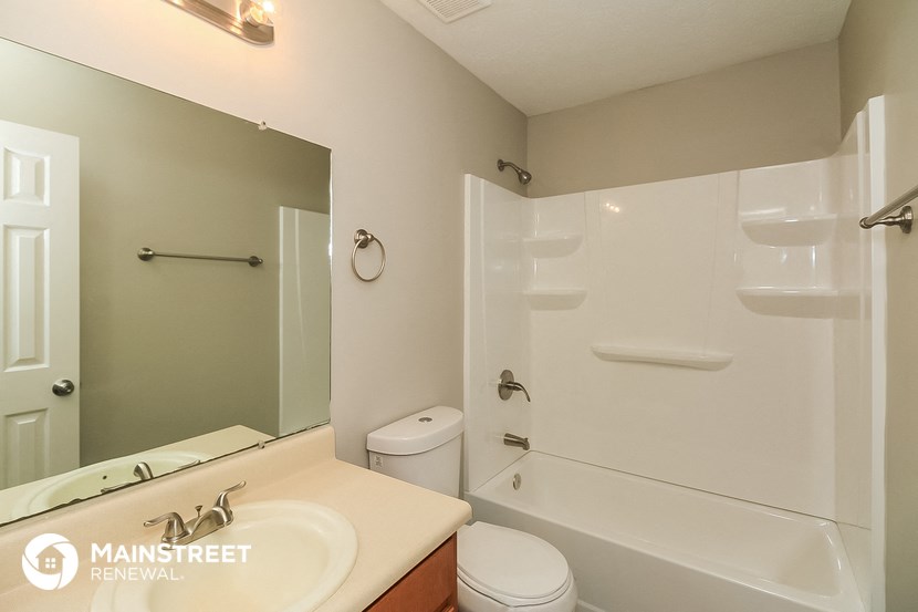 a bathroom with a shower toilet and sink and a mirror