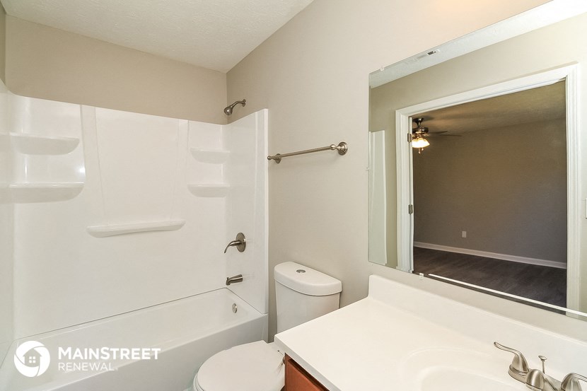 a bathroom with a large mirror and a sink and a toilet