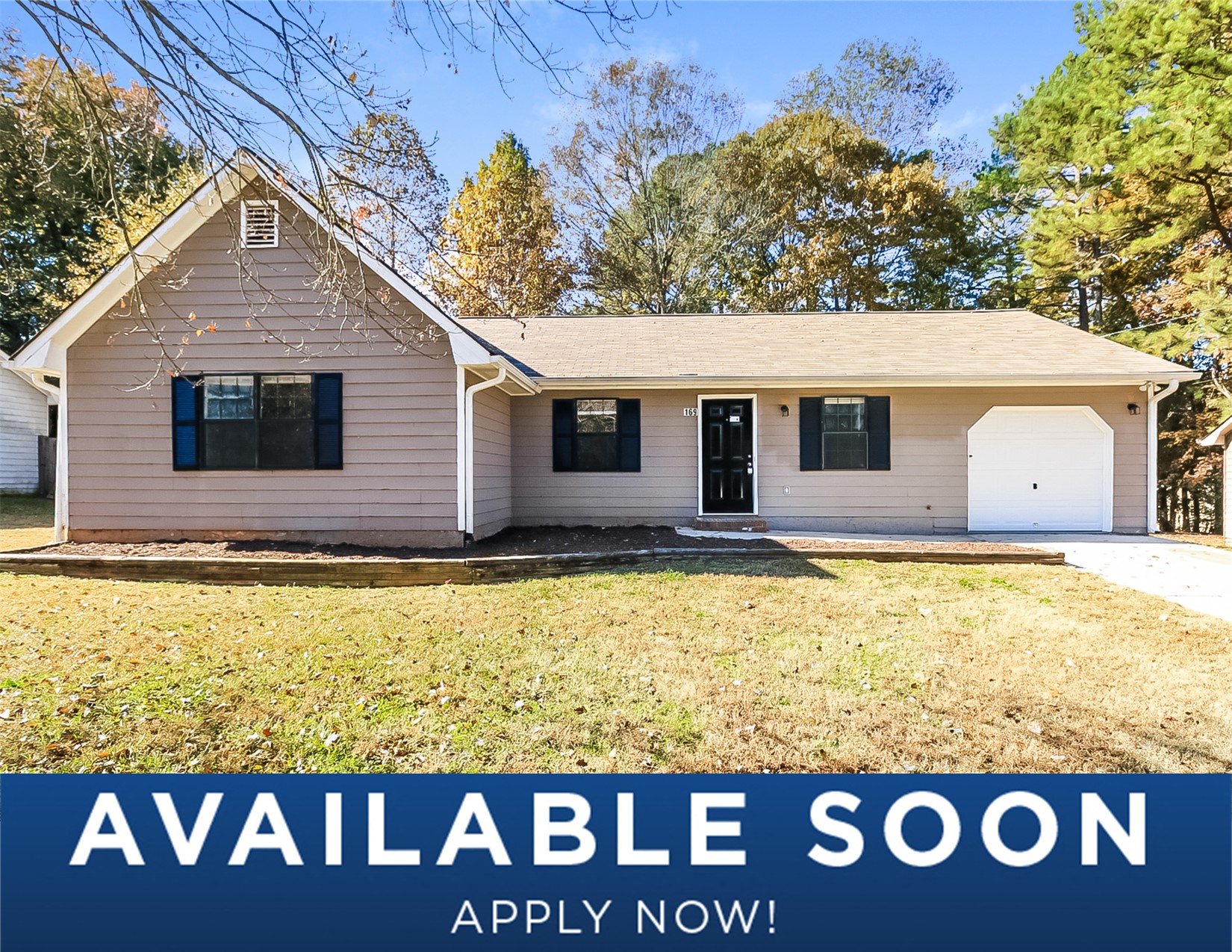 a white house with a lawn and trees in the background