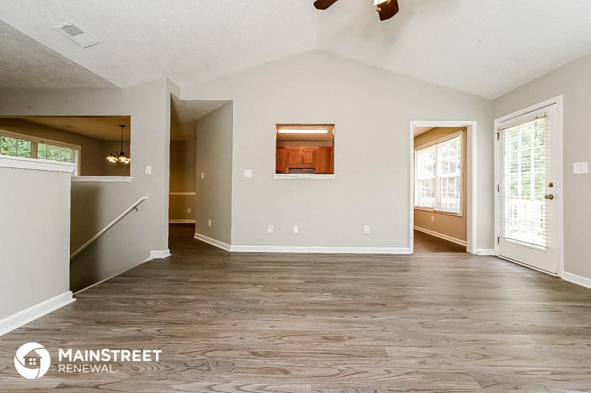 the living room and dining room of an empty house