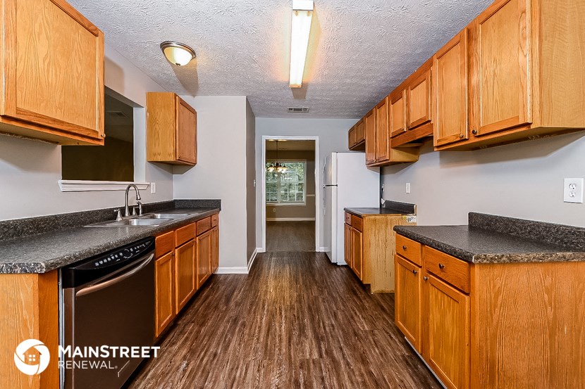 a kitchen with wood flooring and wooden cabinets