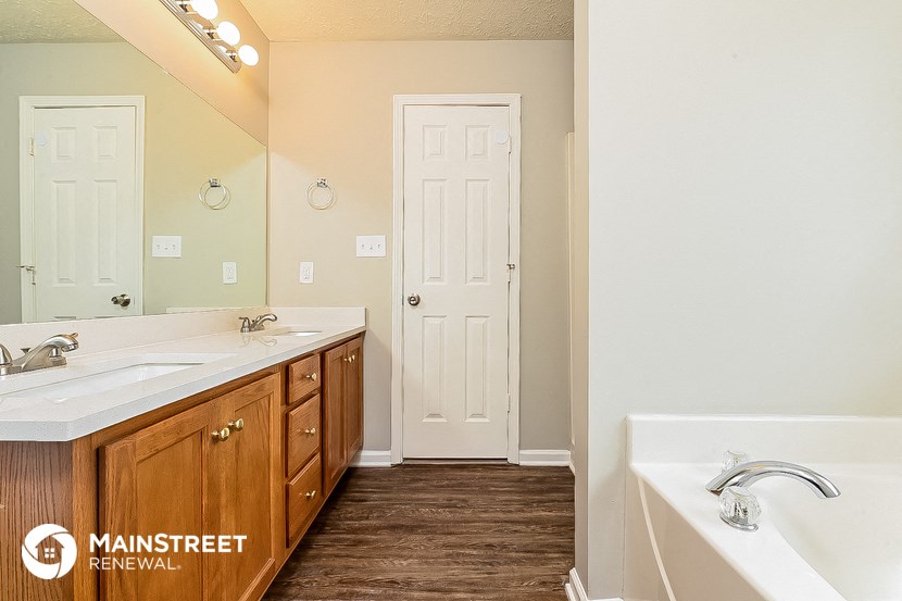 a bathroom with a tub and a sink and a mirror