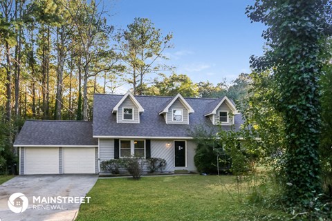 a blue and white house with a yard and trees