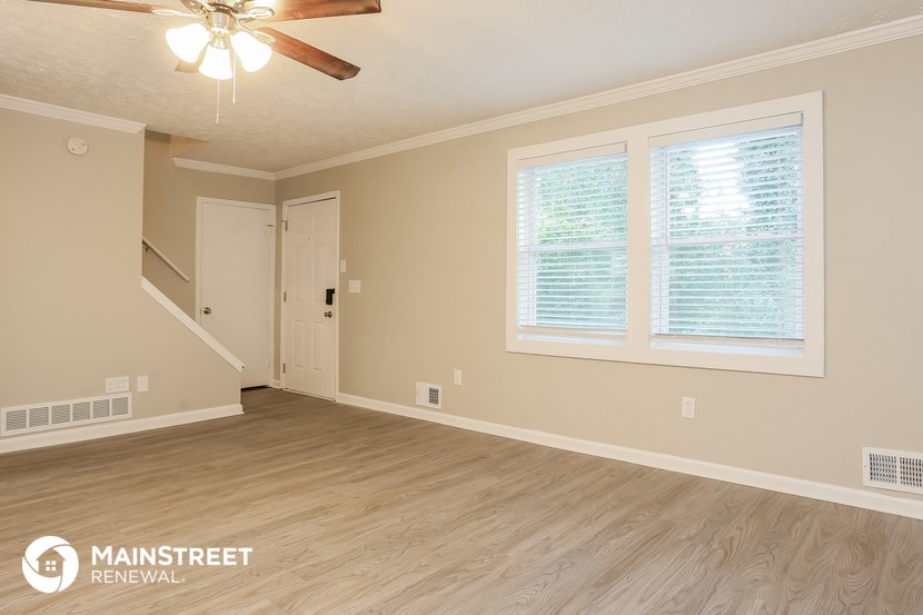 the living room of an empty house with a ceiling fan