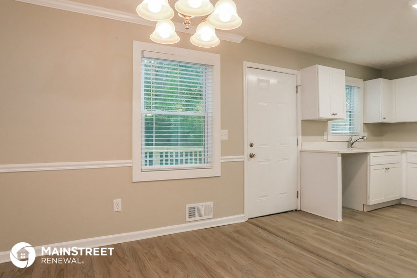 a kitchen with white cabinets and a sink and a window