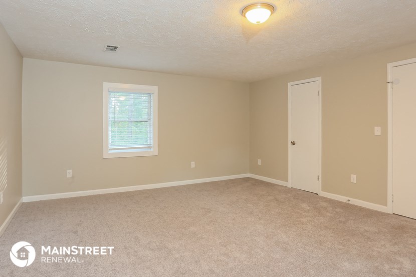 the upstairs bedroom with carpet and a door to the bathroom