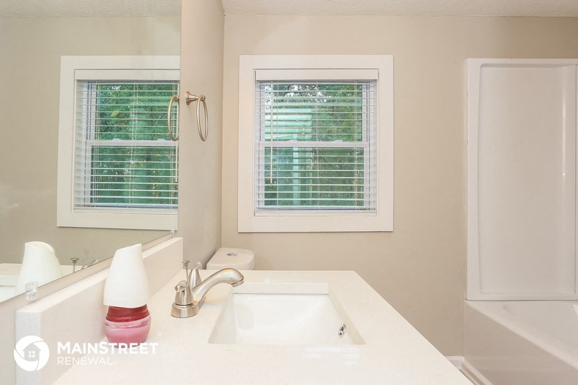 a bathroom with a sink and a mirror and a window