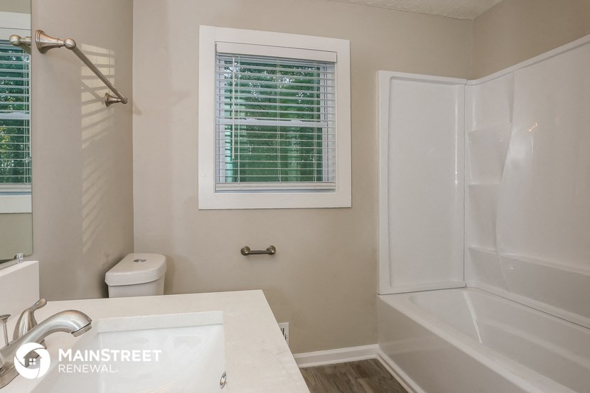 a bathroom with a shower and a sink and a toilet
