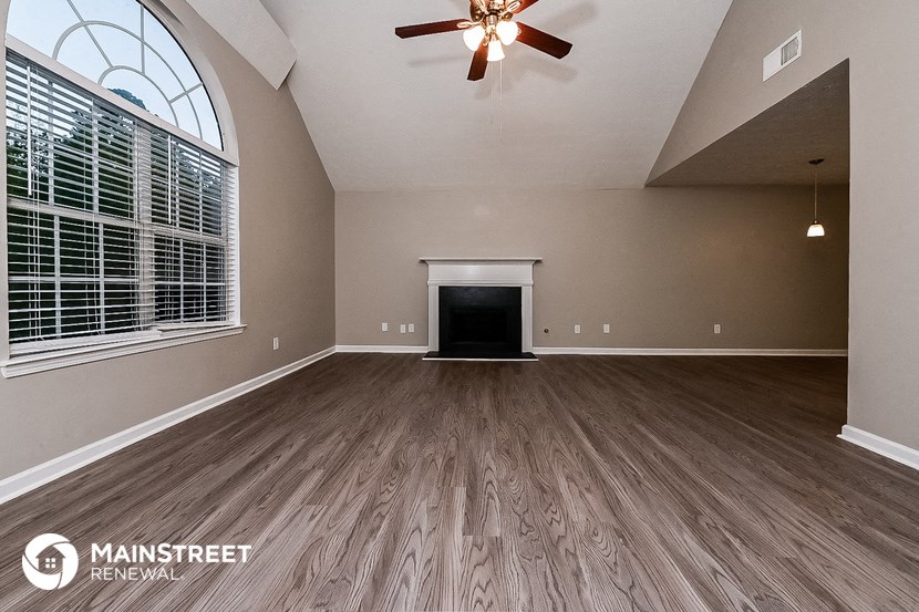 the spacious living room has a fireplace and hardwood floors