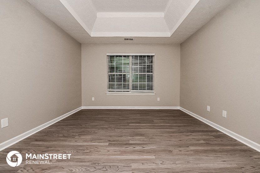 a empty room with wood floors and a window