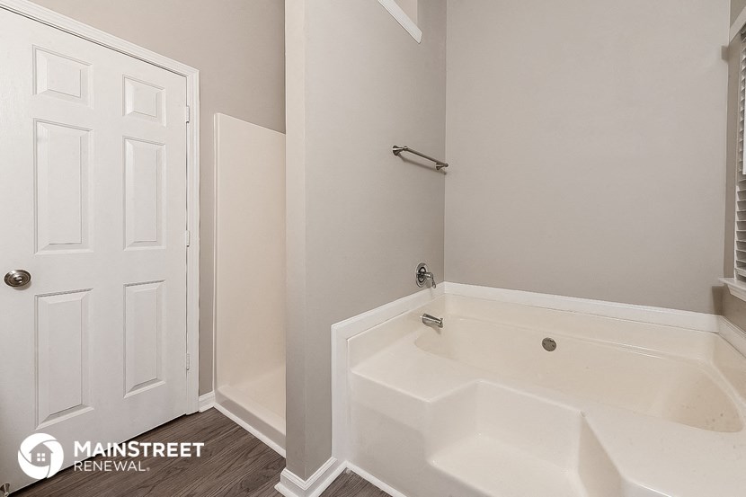 a bathroom with a tub and a white door