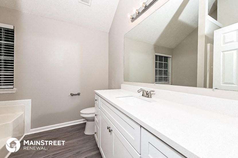 a bathroom with a sink and a toilet and a mirror